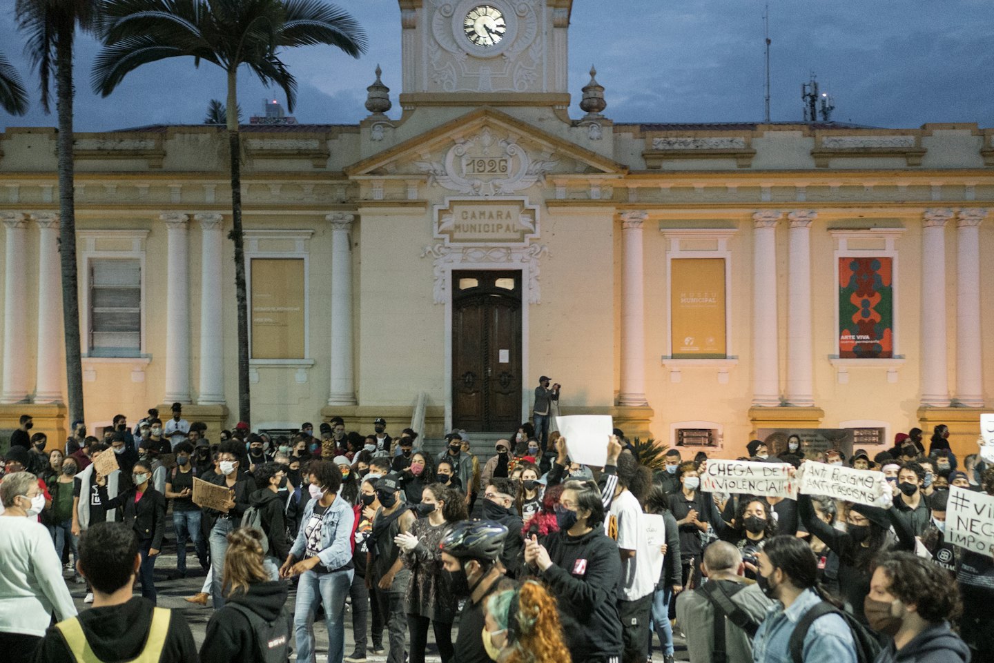 Protesters holding signs in front of a municipal building.